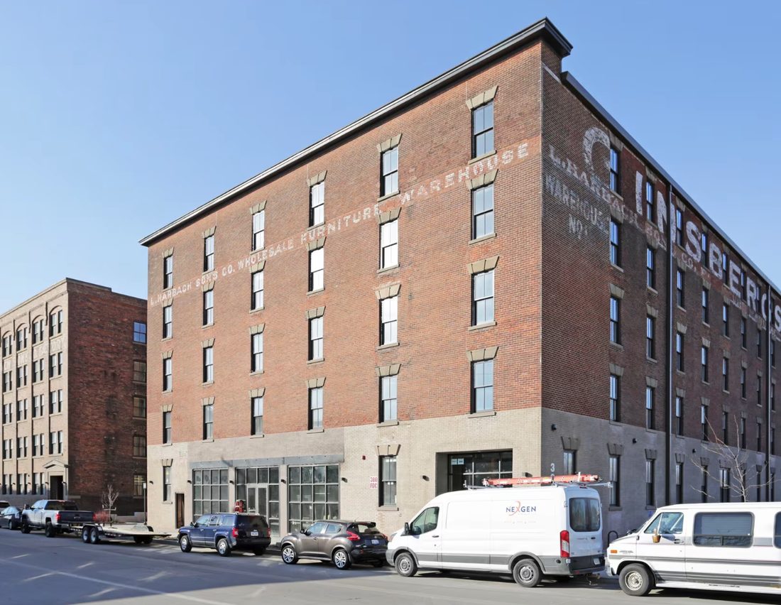 The building's original brick facade, with 'L. Harbach Sons Co. Wholesale Furniture Warehouse' still hand-painted on the wall