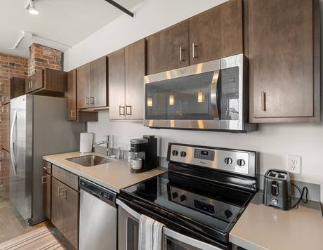 A unit kitchen with an exposed brick column