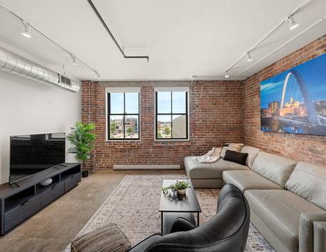 A two-bedroom living room with an industrial accent wall